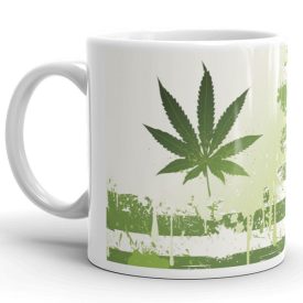 Zöld marihuána és kannabisz leveles mintával díszített fehér kerámia bögre koptatott háttérrel