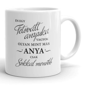 Tetovált anyuka vagyok olyan mint más anya csak sokkal menőbb feliratú fehér kerámia bögre fekete kalligrafikus és nyomtatott betűkkel díszítve.
