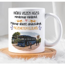 Férfi kézben tartott fehér kerámia bögre kék autóbusz grafikával és vicces sofőr felirattal