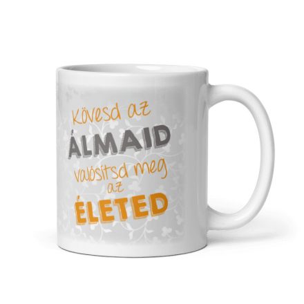 Kövesd az álmaid valósítsd meg az életed feliratú fehér kerámia bögre narancssárga és szürke betűkkel, elegáns halványszürke indás háttérrel.